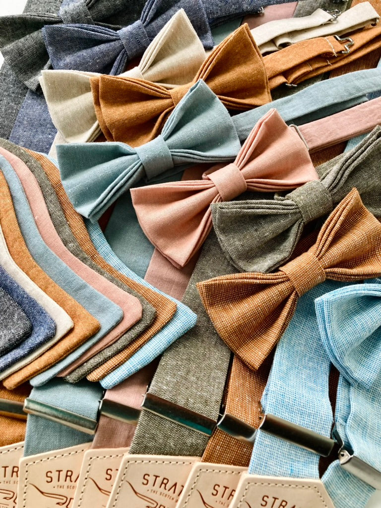 Handmade linen bow ties in vintage-inspired colors — shown in self-tie and pre-tied styles with polished brass hardware. Matching Stratton Suspender Co. suspenders included. Ideal for weddings, groomsmen, and classic menswear.